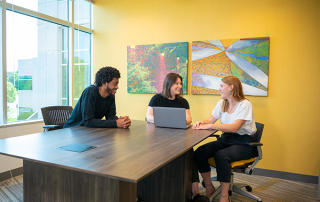 man and two women sitting at conference room