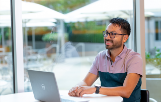 man sitting at table with laptop