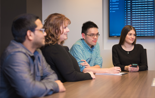 REG-1 four people sitting at conference table